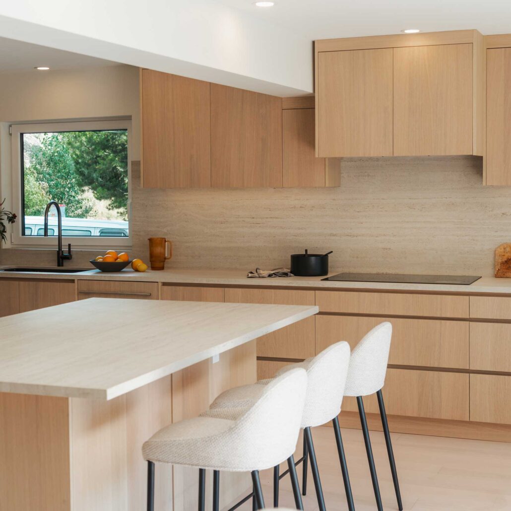 Combined kitchen and dining area with natural wood finishes and modern lighting.