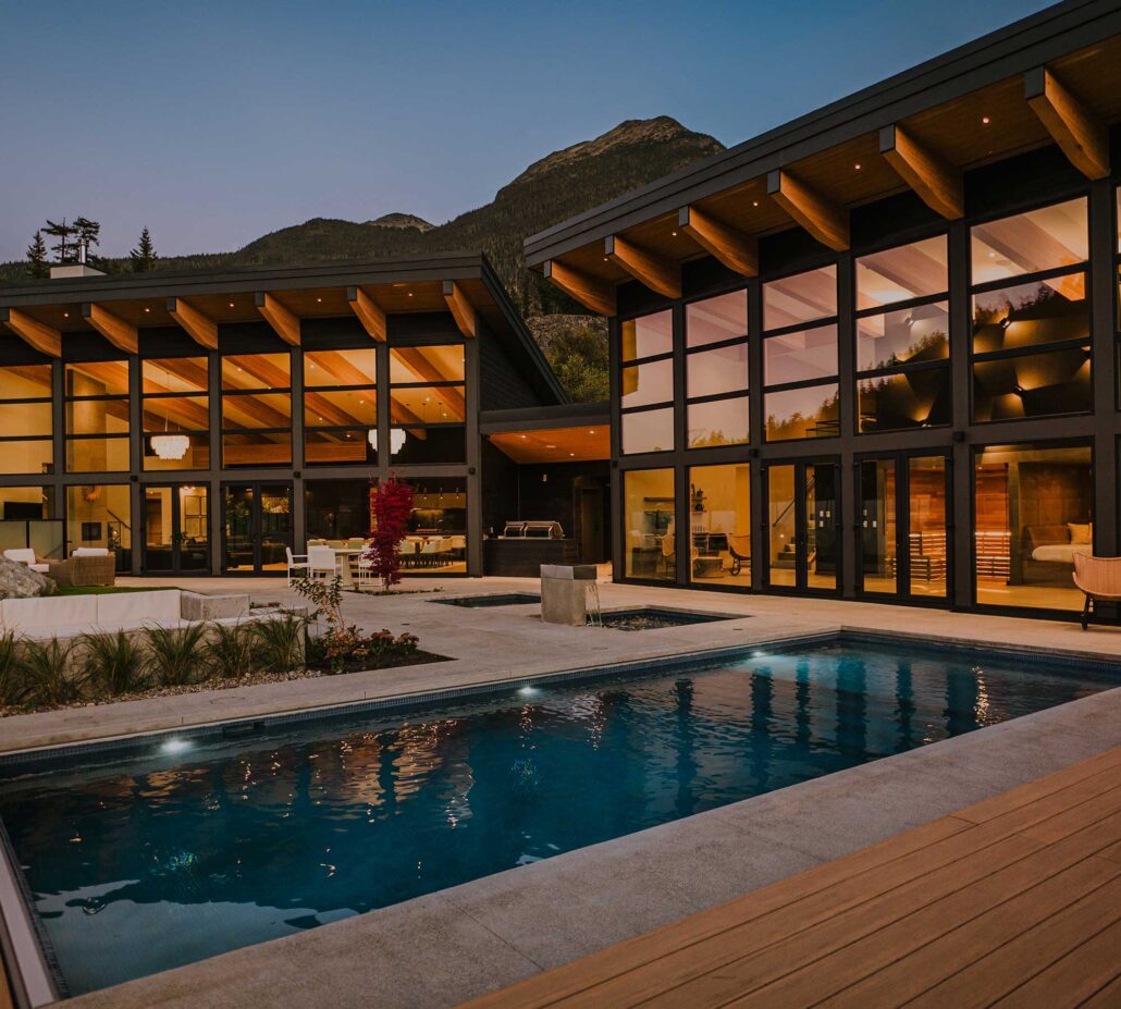 pool at dusk showcasing the light from the inside large windows