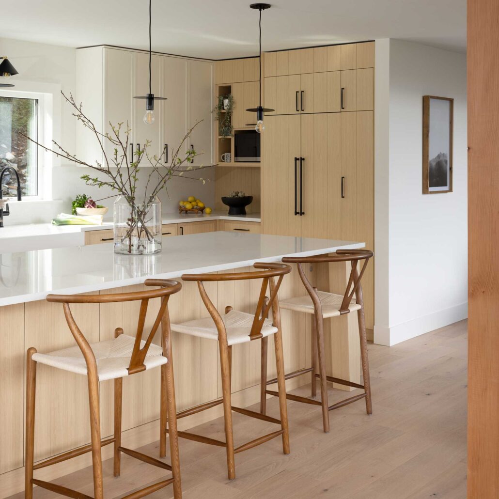 Kitchen with wood cabinetry, bar seating, and clean modern detailing
